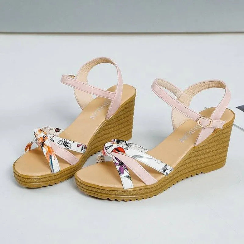 Women's pink wedge sandals with a thick heel, fish mouth design, and an adjustable buckle strap.
