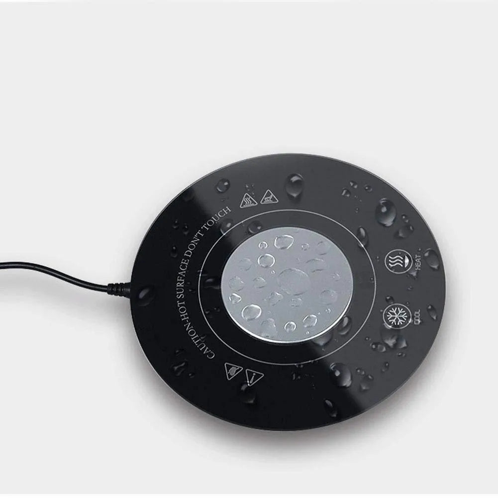 Black USB-powered hot and cold drink coaster with tempered glass top on a wooden desk.
