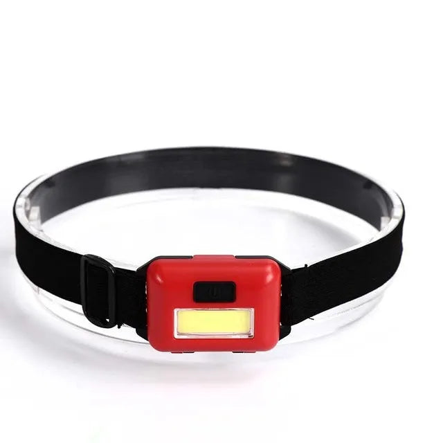 Compact blue outdoor LED headlight with adjustable head strap on a black background.