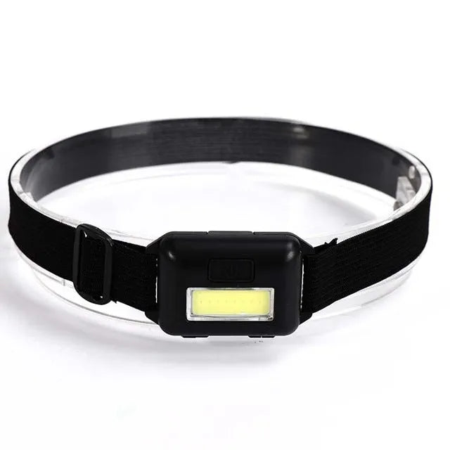 Compact blue outdoor LED headlight with adjustable head strap on a black background.