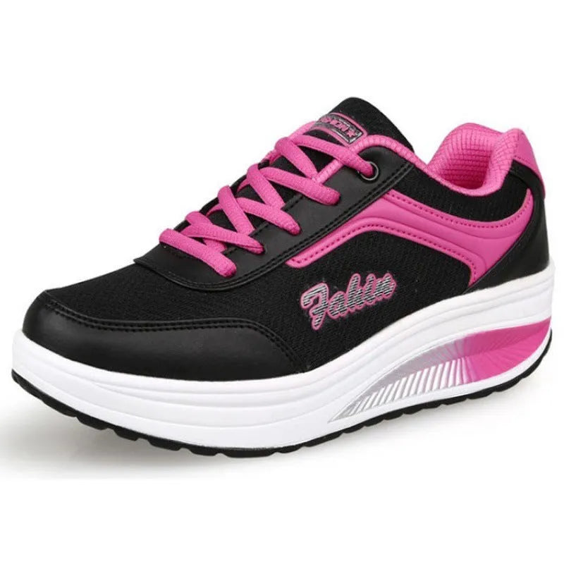 Women's grey pink heelless sports travel shoes with a mid heel on a neutral background.