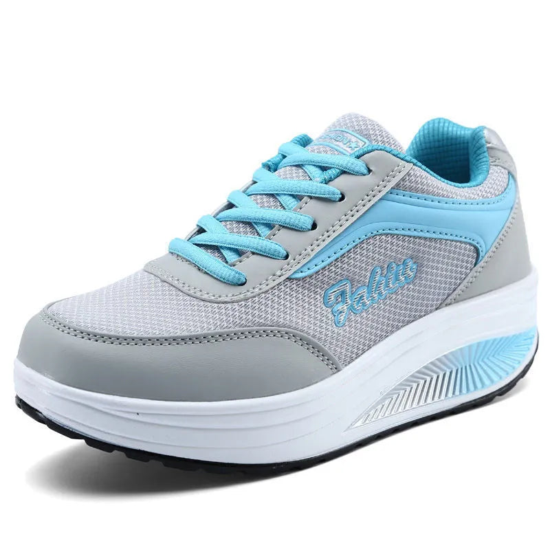 Women's grey pink heelless sports travel shoes with a mid heel on a neutral background.