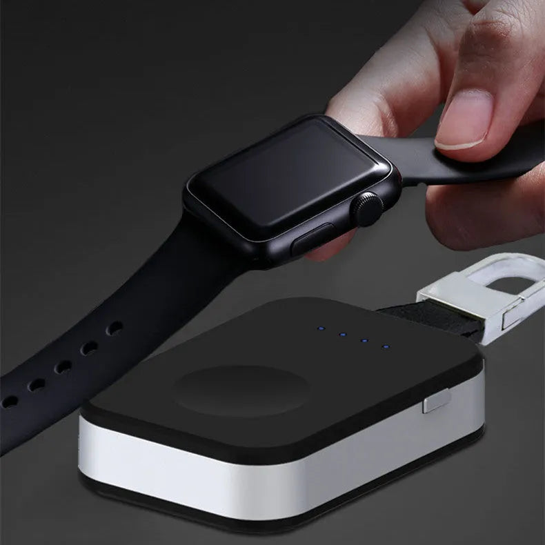 Black Apple Watch portable power bank keychain charger with USB port shown next to an Apple Watch.