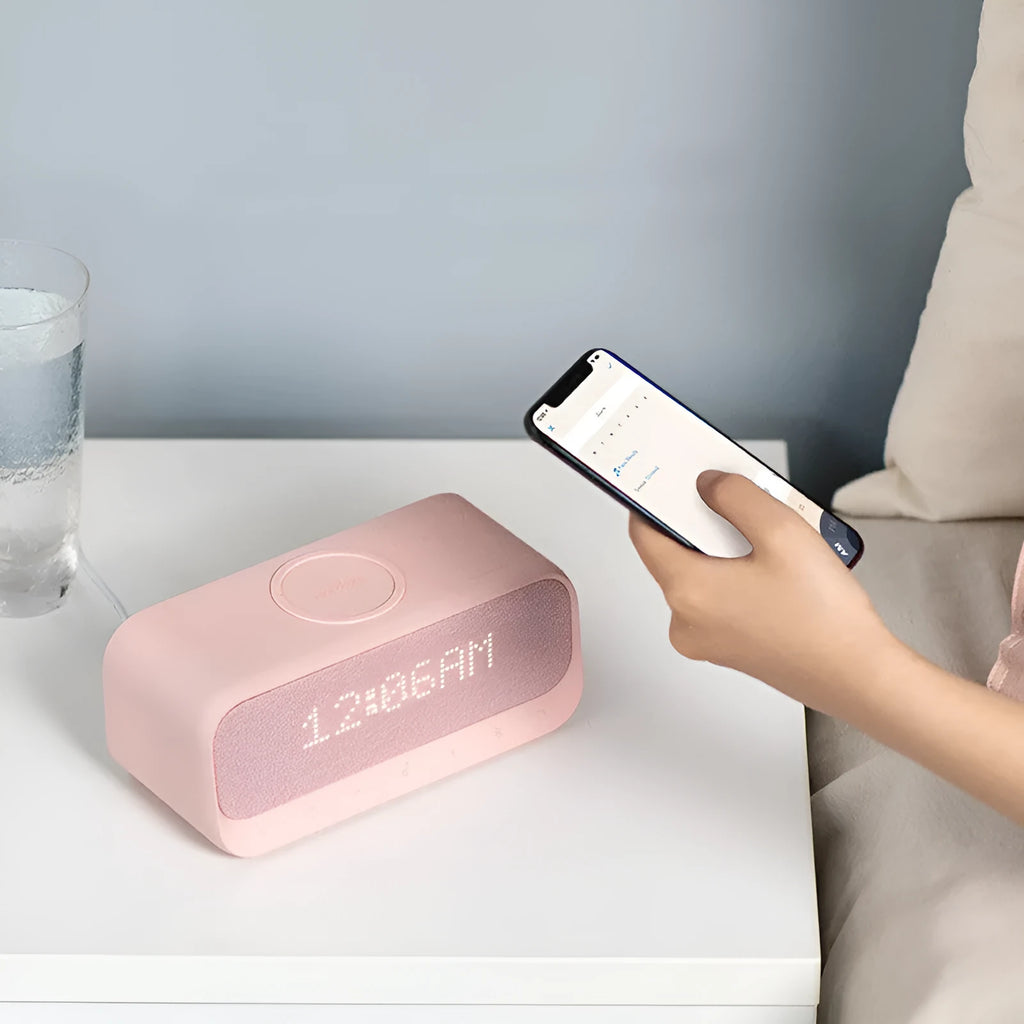 White Soundcore Bluetooth speaker with wireless charging top and digital display.