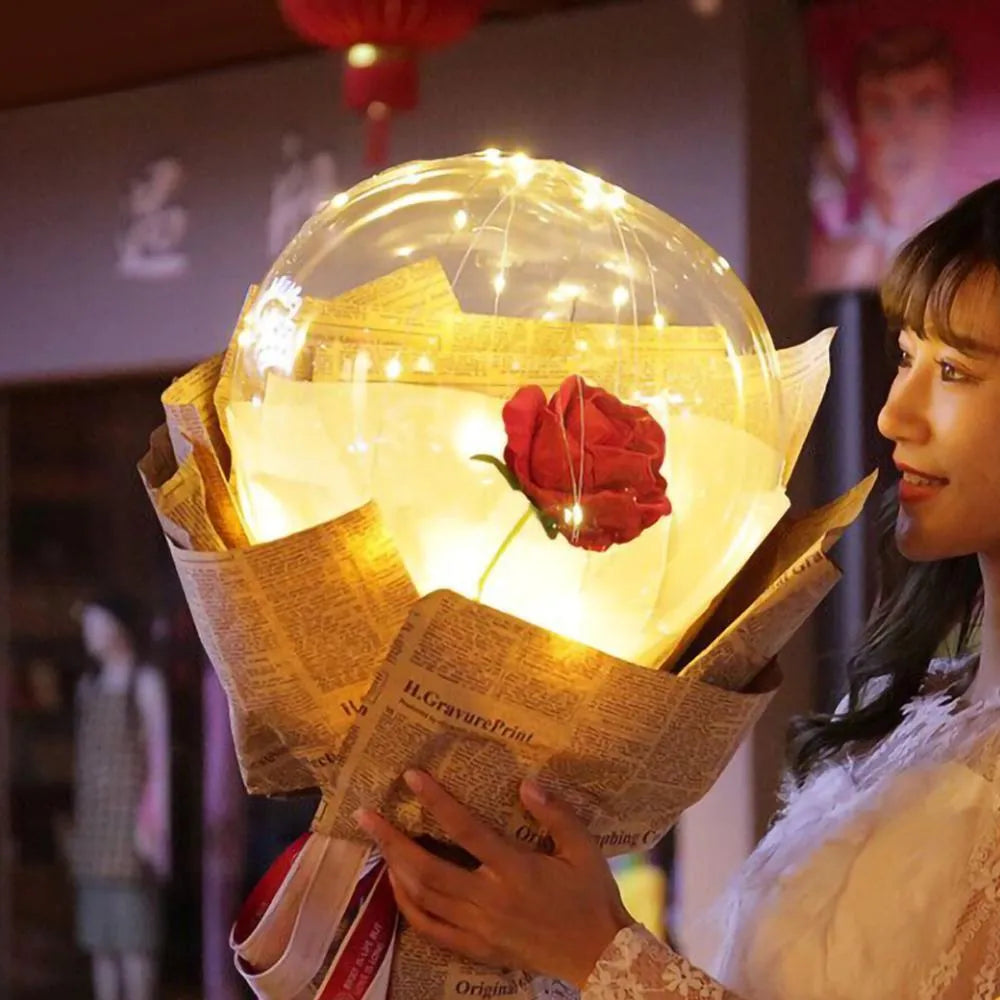 Transparent LED luminous balloon bouquet with artificial rose and glowing light inside, displayed as a DIY kit.