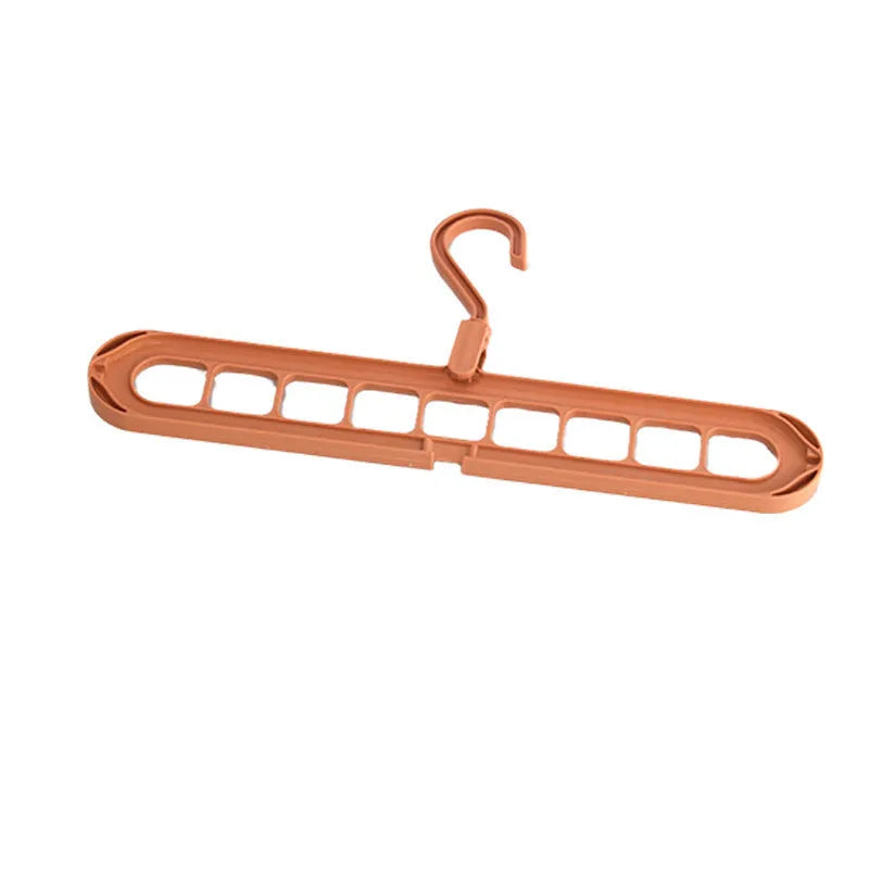 Green plastic multifunctional hanger with nine arms for folding trousers, shown hanging on a rail.