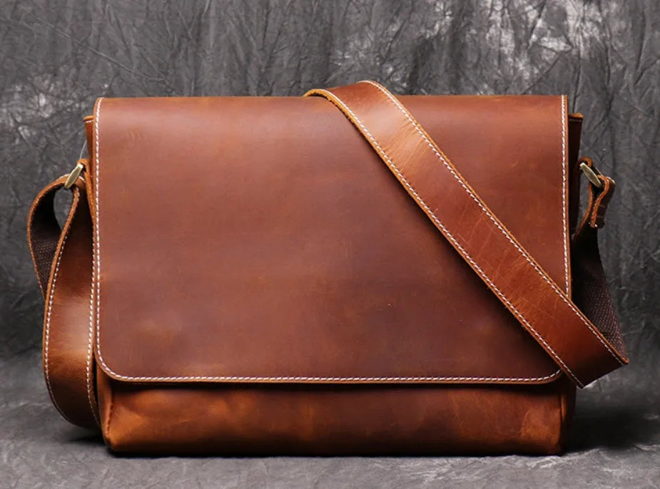 Brown vintage leather men's messenger bag with a flap opening and an adjustable shoulder strap.