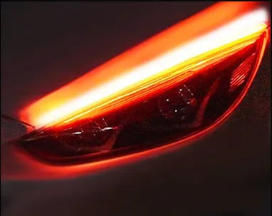 Universal car LED daytime running light strip with flowing turn signal on a vehicle headlight.