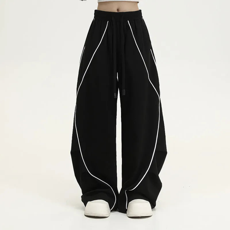 Black pleated hip hop wide-leg pants with stripe pattern showing mid-waist and loose fit