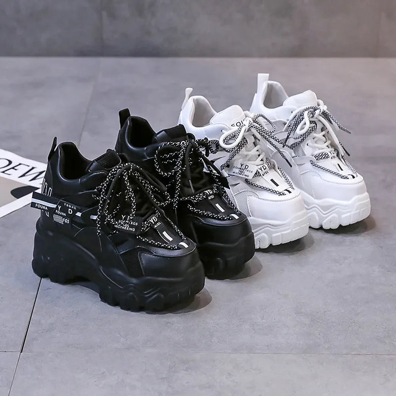 White and black women's low-top mesh platform sports shoes with cross strap and round toe.