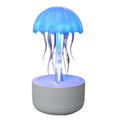 White jellyfish-shaped humidifier and essential oil diffuser with colourful LED night light on a desktop.