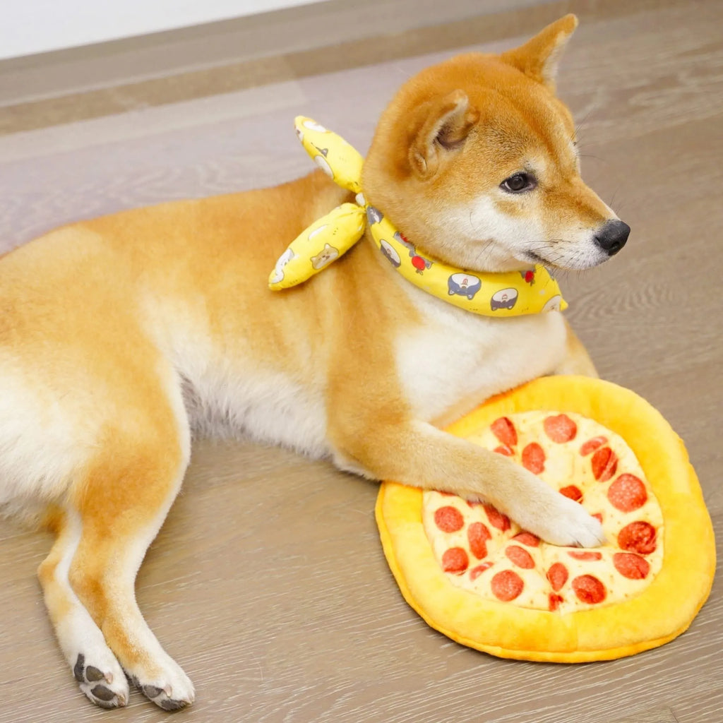 Yellow pizza slice shaped rubber dog chew toy with textured ridges and a squeaker.