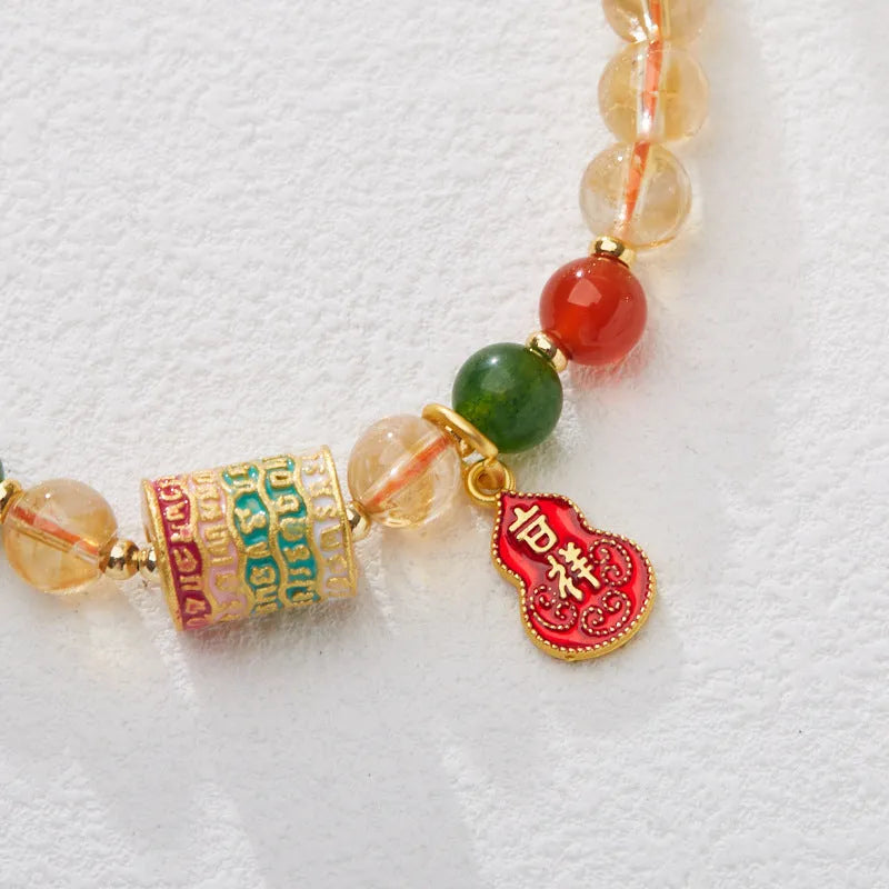 Hand-woven citrine five sutra bracelet with 6mm geometric beads on a wrist.