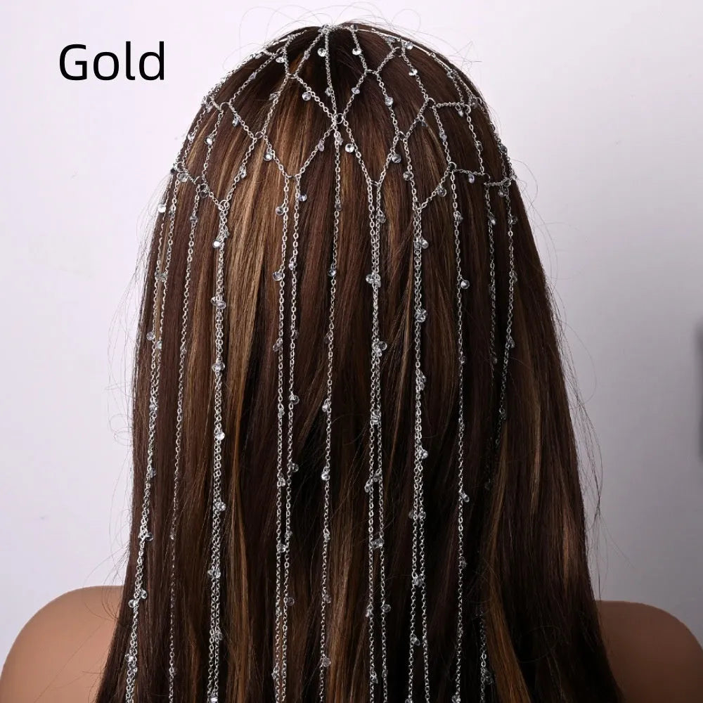 Close-up of a gold metallic mesh headband with rhinestone details and hanging tassels.