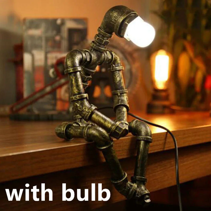 Green bronze vintage industrial robot desk lamp with iron pipe design on a wooden table.