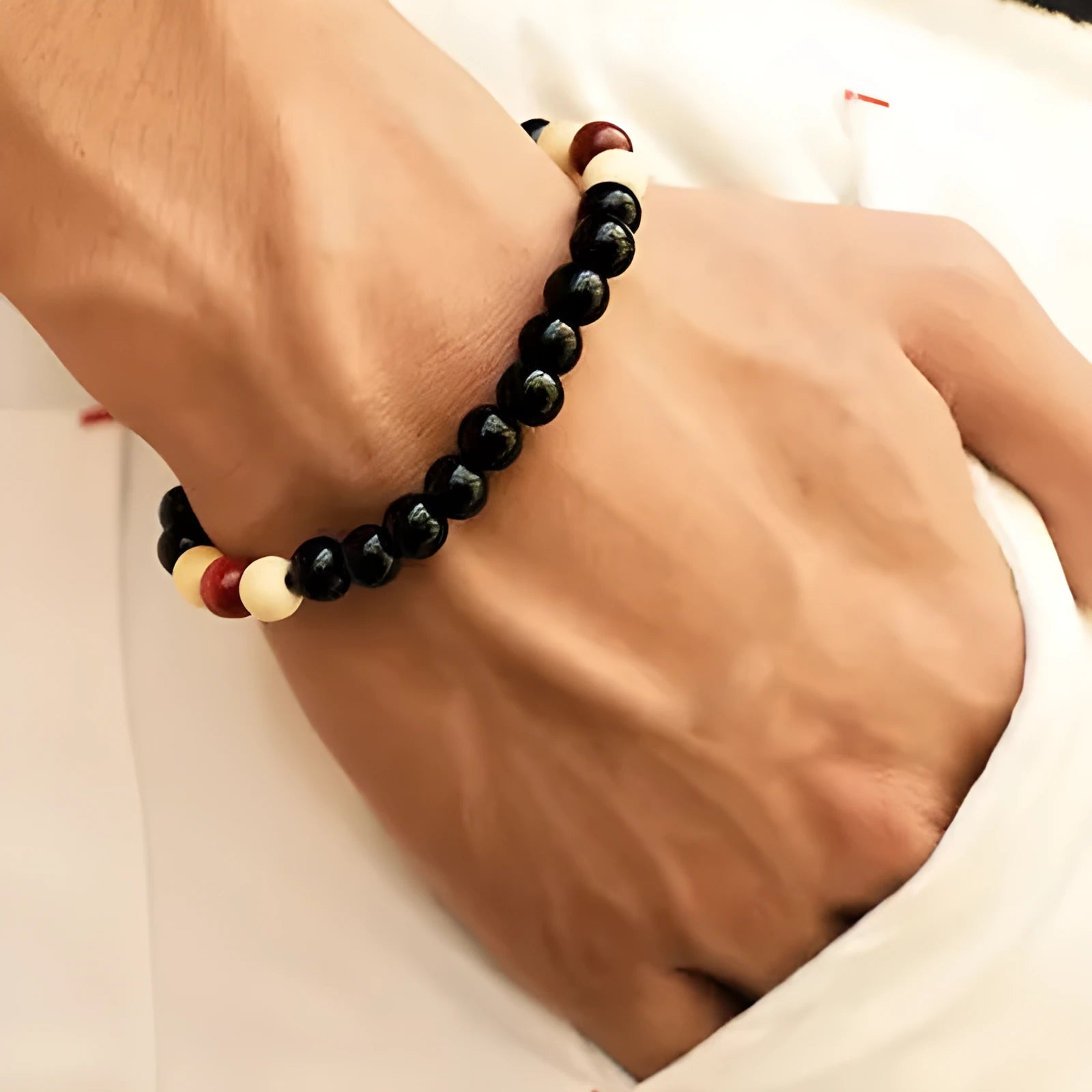 Unisex ethnic-style beaded bracelet with lava stone on a wrist, showing essential oil application.