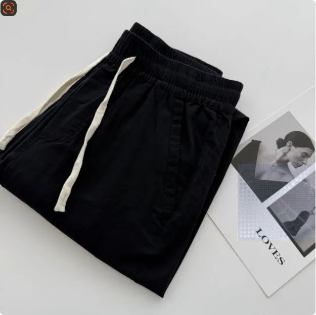 Men's beige loose-fit straight-leg casual pants with a drawstring waistband on a hanger.