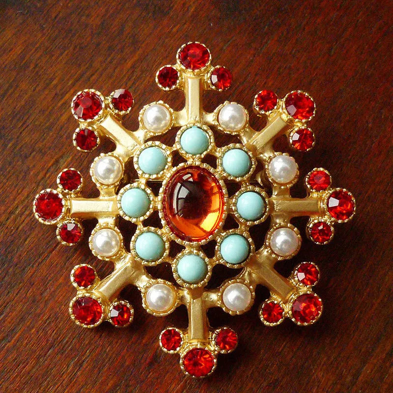 A vintage-style baroque brooch made of zinc alloy in a diamond shape on a fabric background.