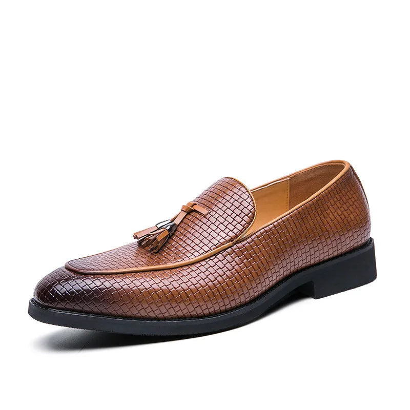 Men's black pointed toe slip on loafers with a tassel detail on the front, shown on a plain background.