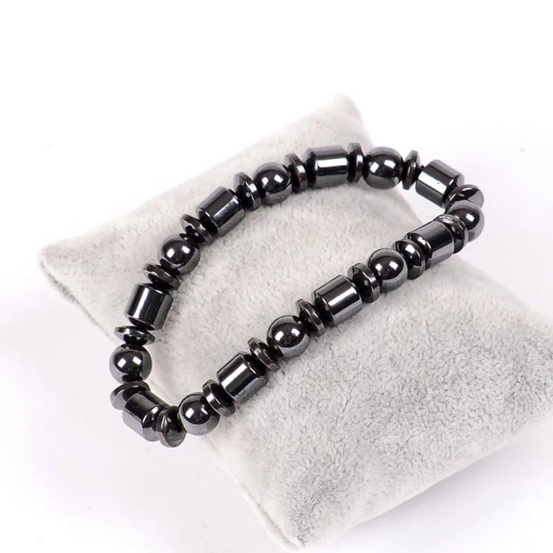 Black pentagram magnetic bracelet with magnetite and hematite stones on a wrist.
