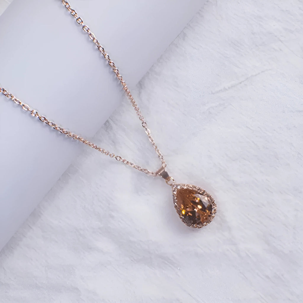 Pink water drop geometric necklace with rose gold electroplating and rhinestone detailing on alloy pendant