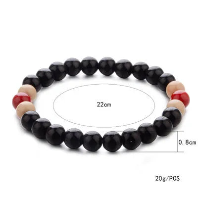 Unisex ethnic-style beaded bracelet with lava stone on a wrist, showing essential oil application.