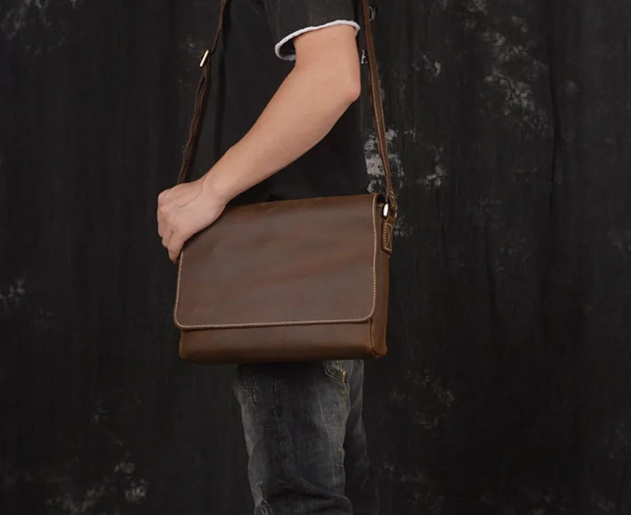 Brown vintage leather men's messenger bag with a flap opening and an adjustable shoulder strap.