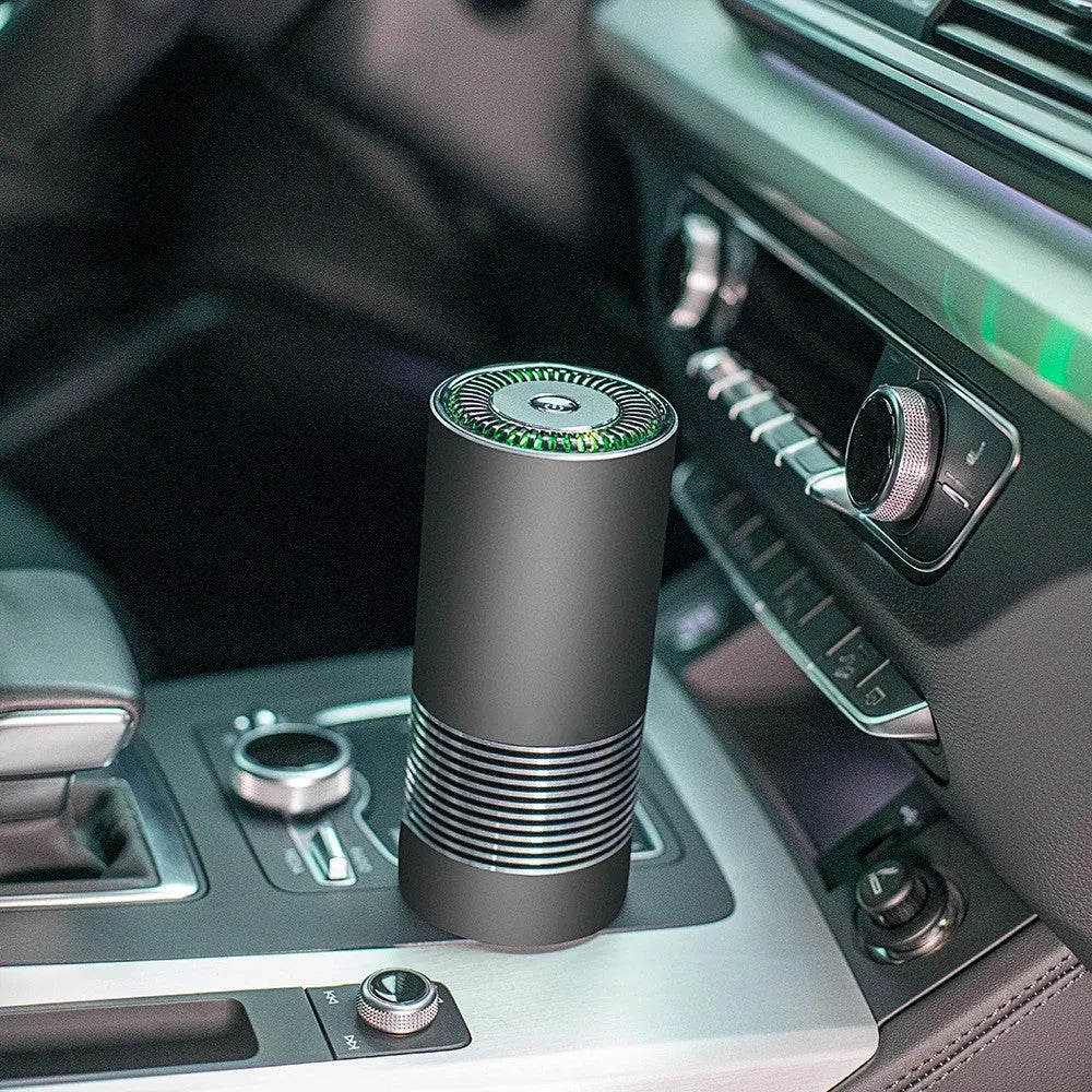 Compact cylindrical car air purifier in metallic grey with aluminium alloy casing.