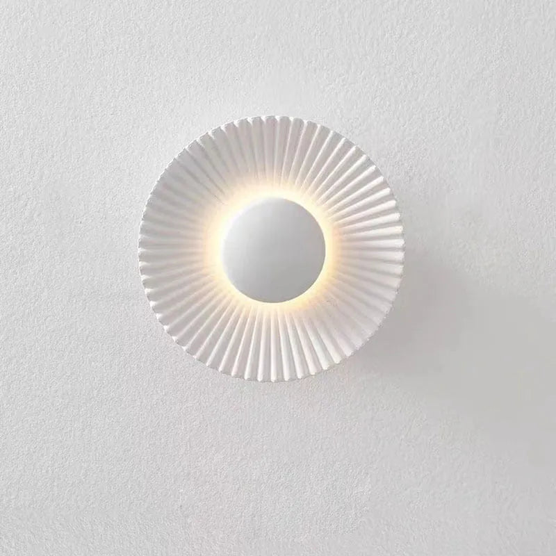 Round aluminium wall lamp with outer white and inner gold finish mounted on a wall