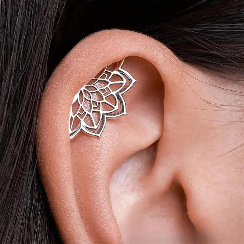 A pair of geometric spider web design stud earrings in an electroplated gold finish.