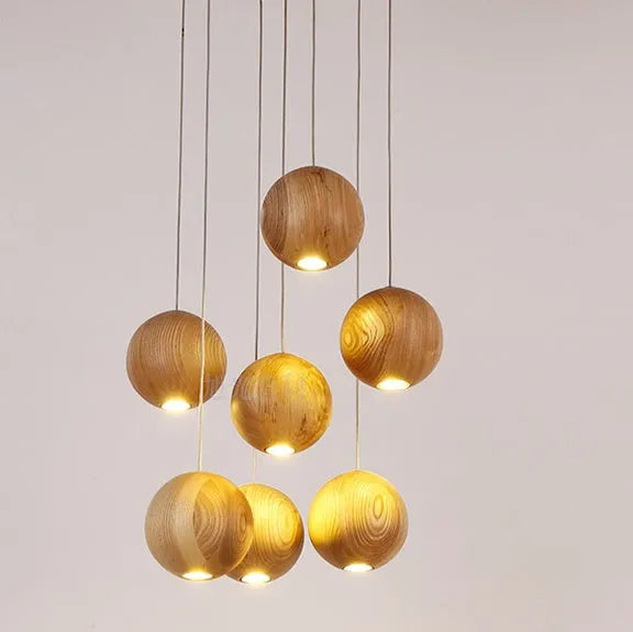 Nordic-style wooden ball chandelier with adjustable cord, shown in single-head and three-head styles on a wood disc base.