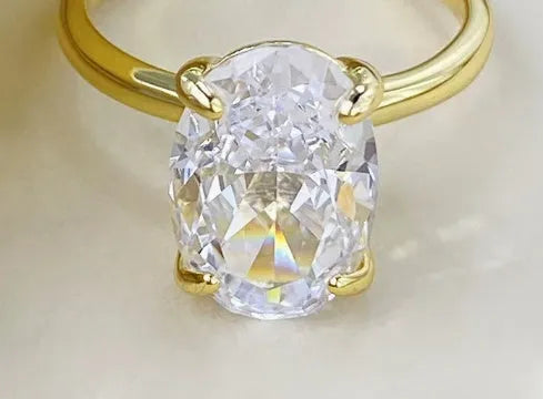 Oval women's ring with four-prong claw setting in gold or silver finish on a 9 silver band.