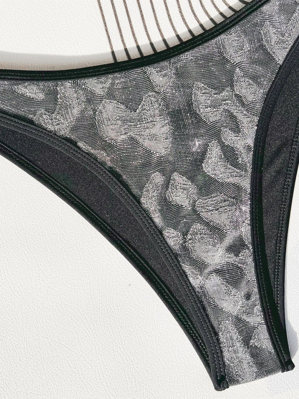 Black ladies bikini strap swimsuit made from polyester fabric, showing front and back views.