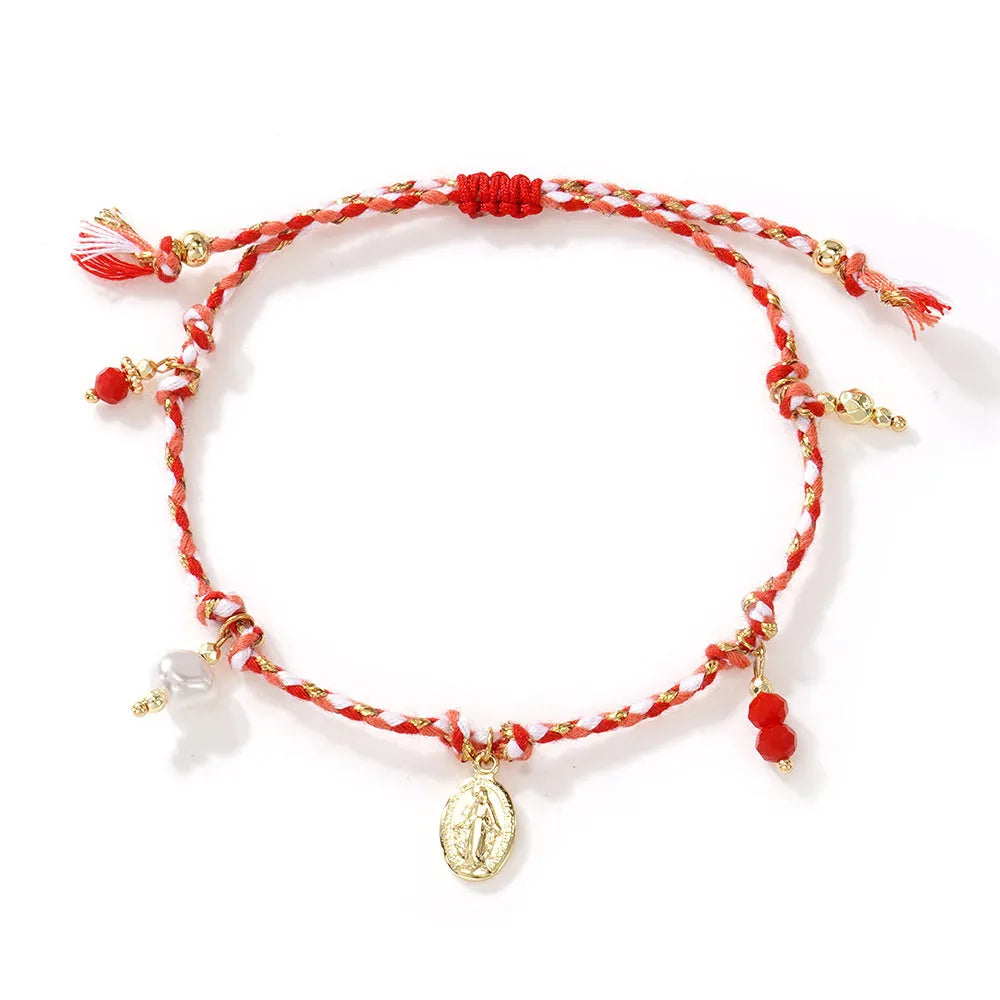 Close-up of a woman's hand-woven colourful braided rope bracelet with an adjustable strap tag.
