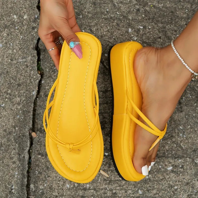 White thick bottom flip-flops with herringbone pattern and round toe on a rubber sole.