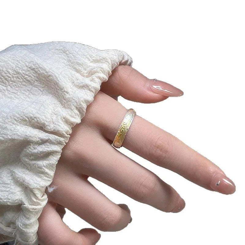Open mouth silver and gold ring with a geometric Xiangyun pattern on a white copper band.