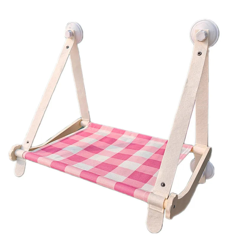 Wooden frame cat hammock with linen cushion mounted on a window, shown in green colour.