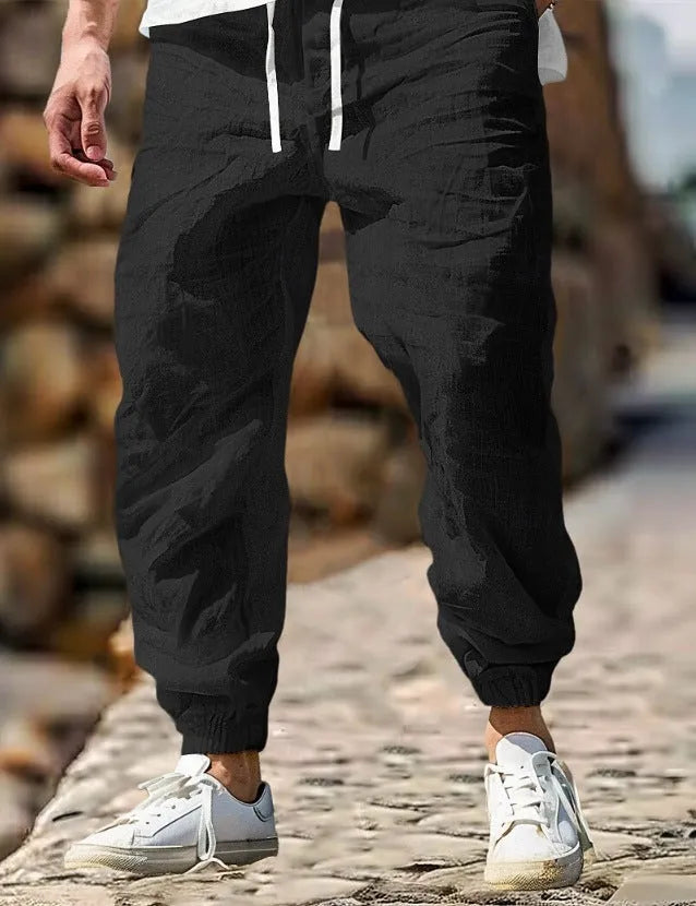 Men's beige straight leg linen trousers with elastic waistband laid flat