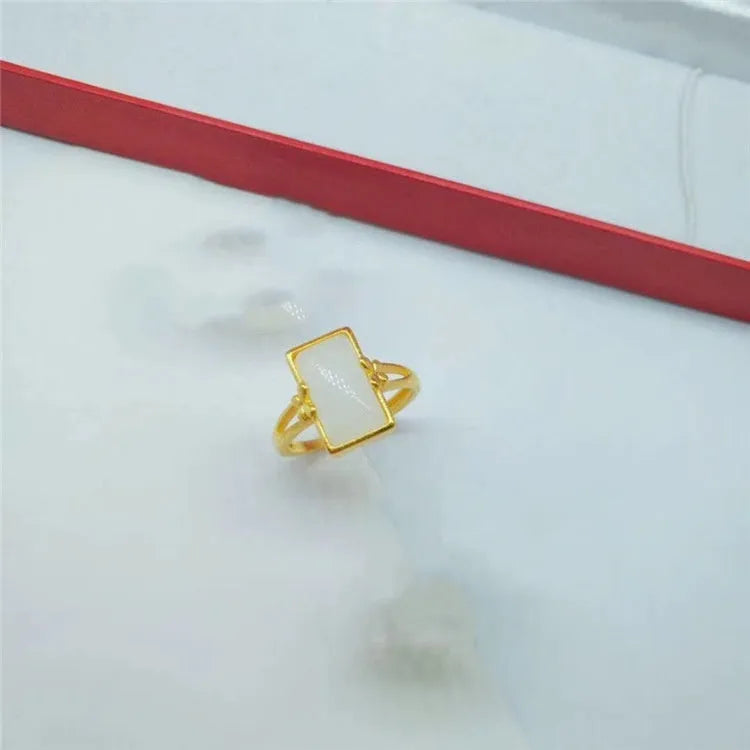 Adjustable brass gold-plated ring with a centre gemstone, shown in black, green, and white colour options.