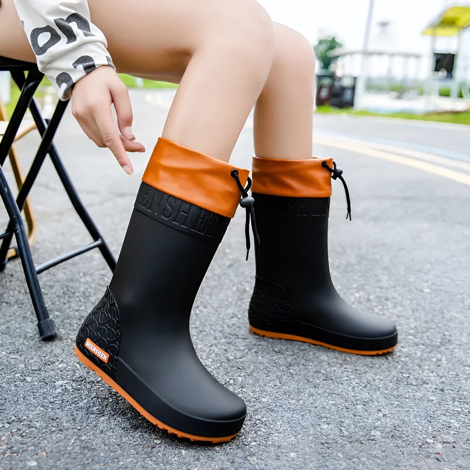 Women's solid colour PVC rain boots with non-slip sole in apricot, black, brown, or pink.
