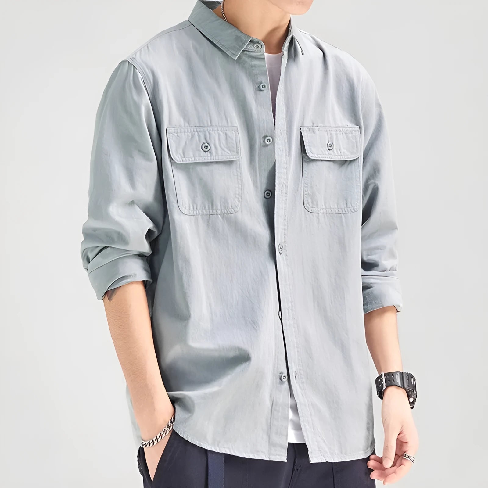 Man wearing a loose fit, long sleeve cardigan-style shirt overall in khaki polyester fabric.
