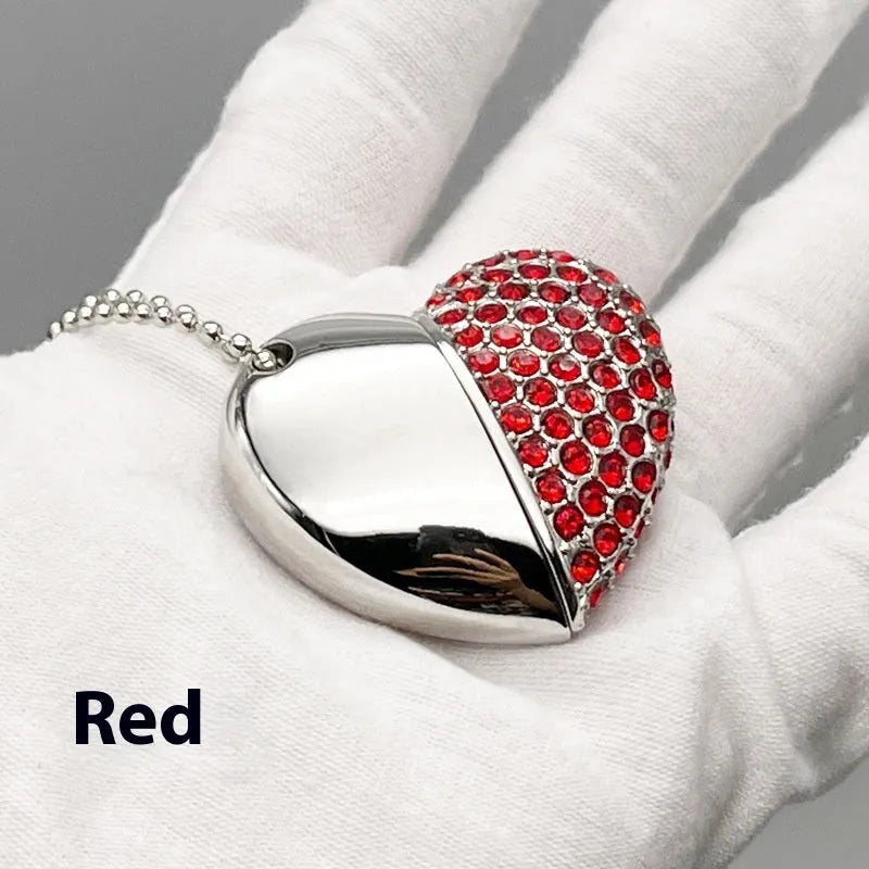 A heart-shaped silver USB flash drive with a brick pattern, shown next to a laptop.