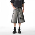 Grey loose-fit denim shorts with a water-washed finish and distressed hole details.