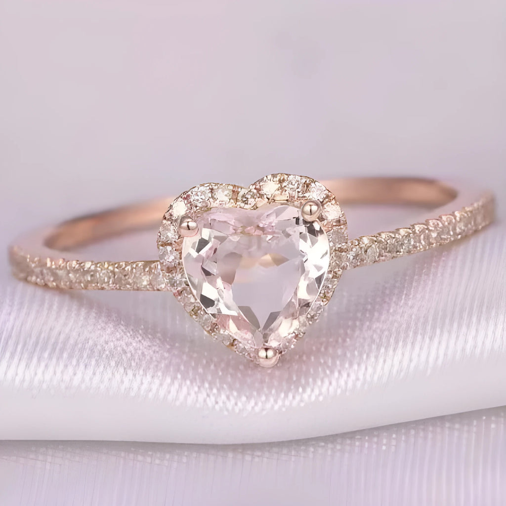 Close-up of a women's heart-shaped ring with a clear crystal centre in rose gold or silvery finish.