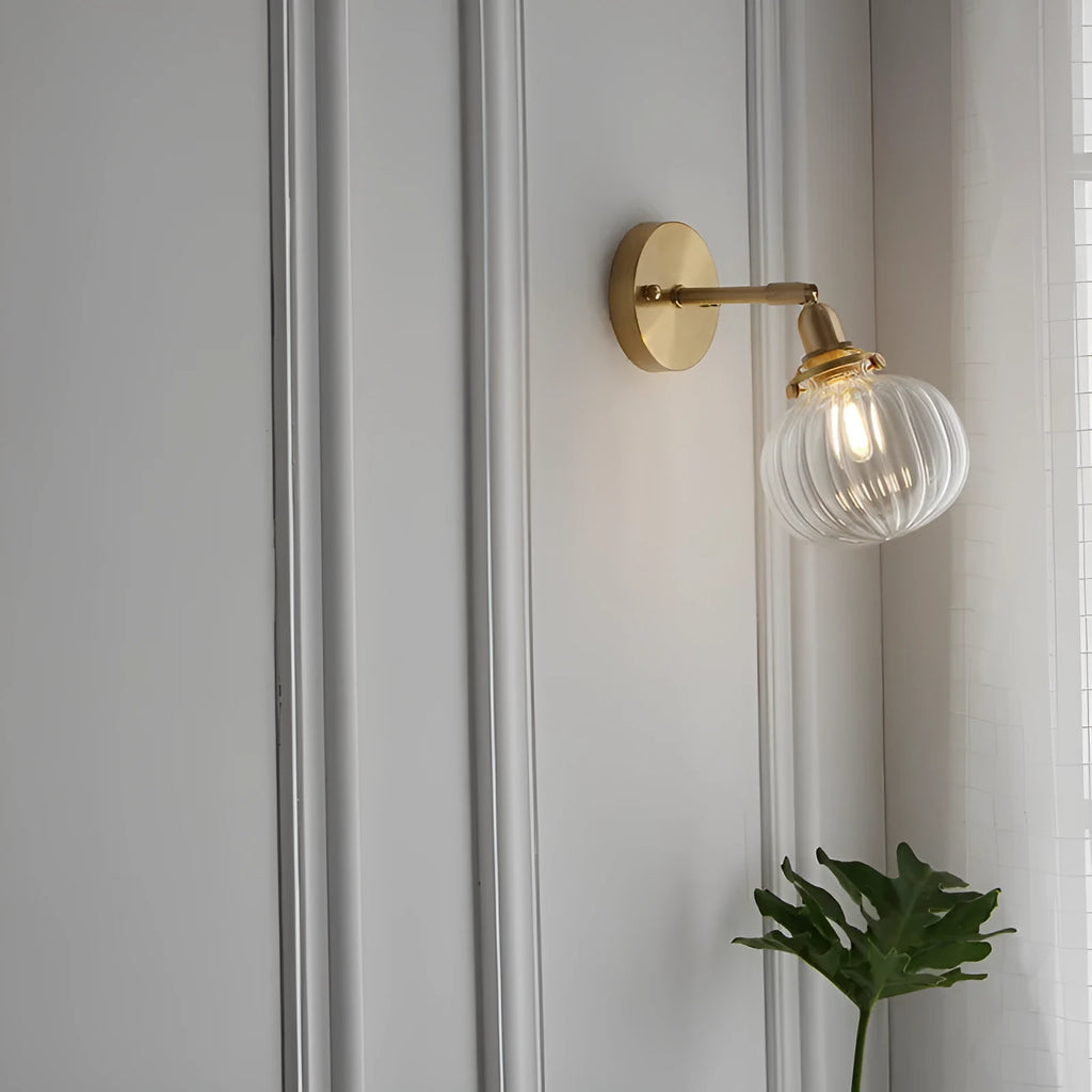 Pumpkin-shaped glass wall lamp with a curved shade on a wall, shown in water ripple transparent and solid blue glass options.