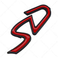 Red and silver SD-shaped metal decorative sticker for cars next to smaller red and black D-shaped sticker.