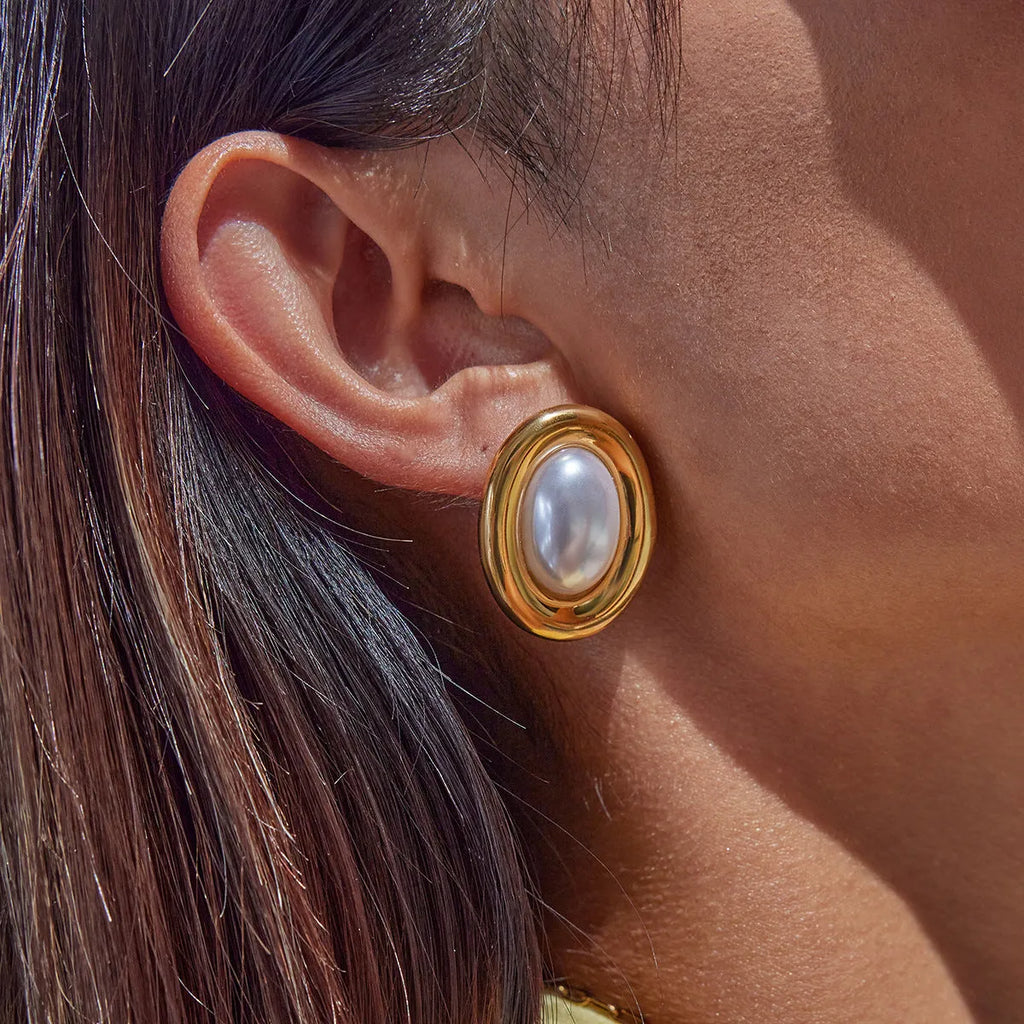 Close-up of a pair of stainless steel vintage-style stud earrings with a pearl detail in JDE0305051 colour.
