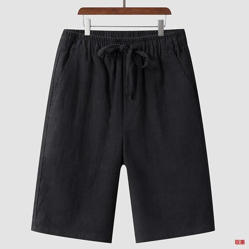 Men's beige linen casual shorts with loose cropped fit and elastic waistband laid flat