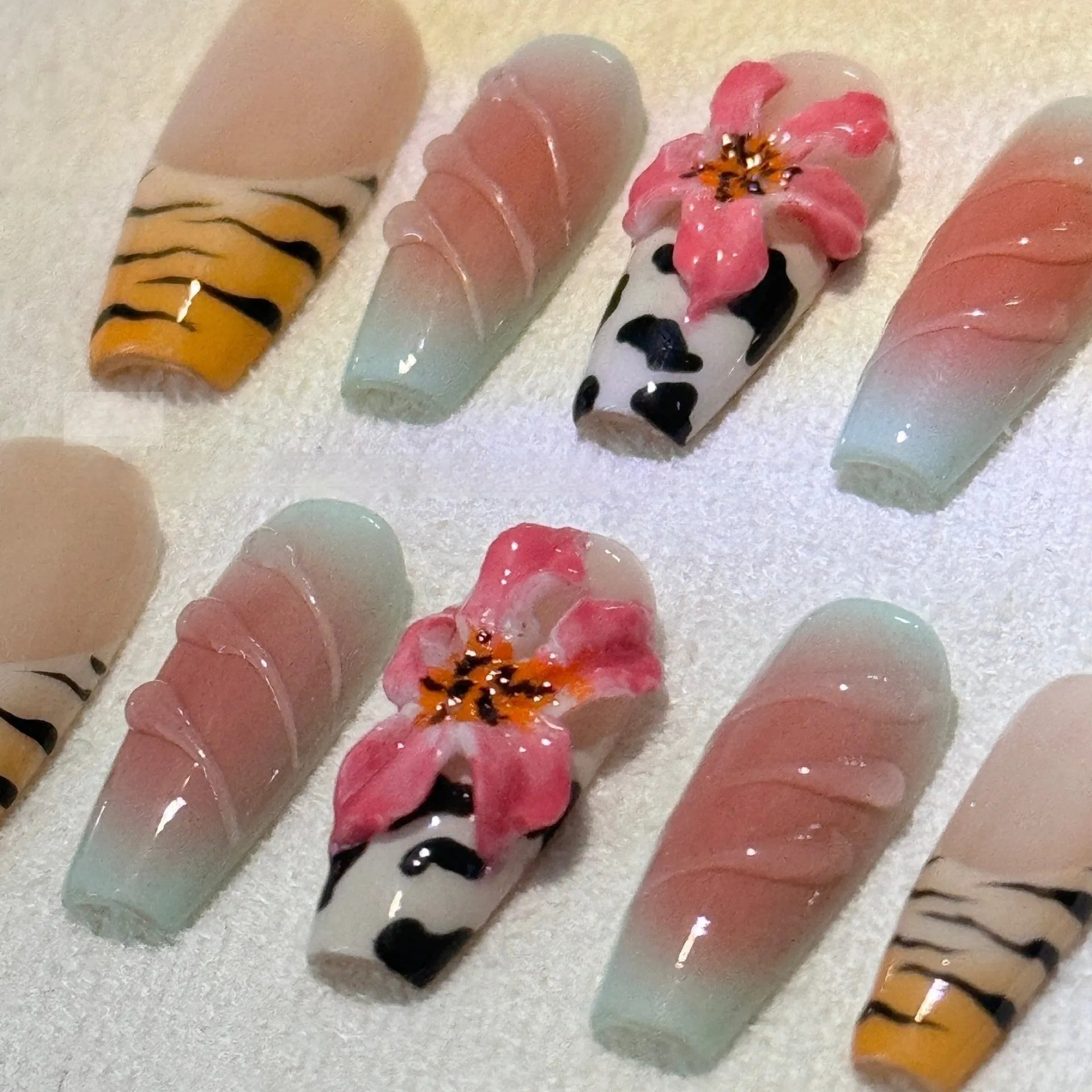 Set of nail art stickers showing zebra pattern and lily flower designs with embossed texture.