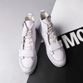 Man wearing black PU leather high-top sneaker style winter ankle boots.
